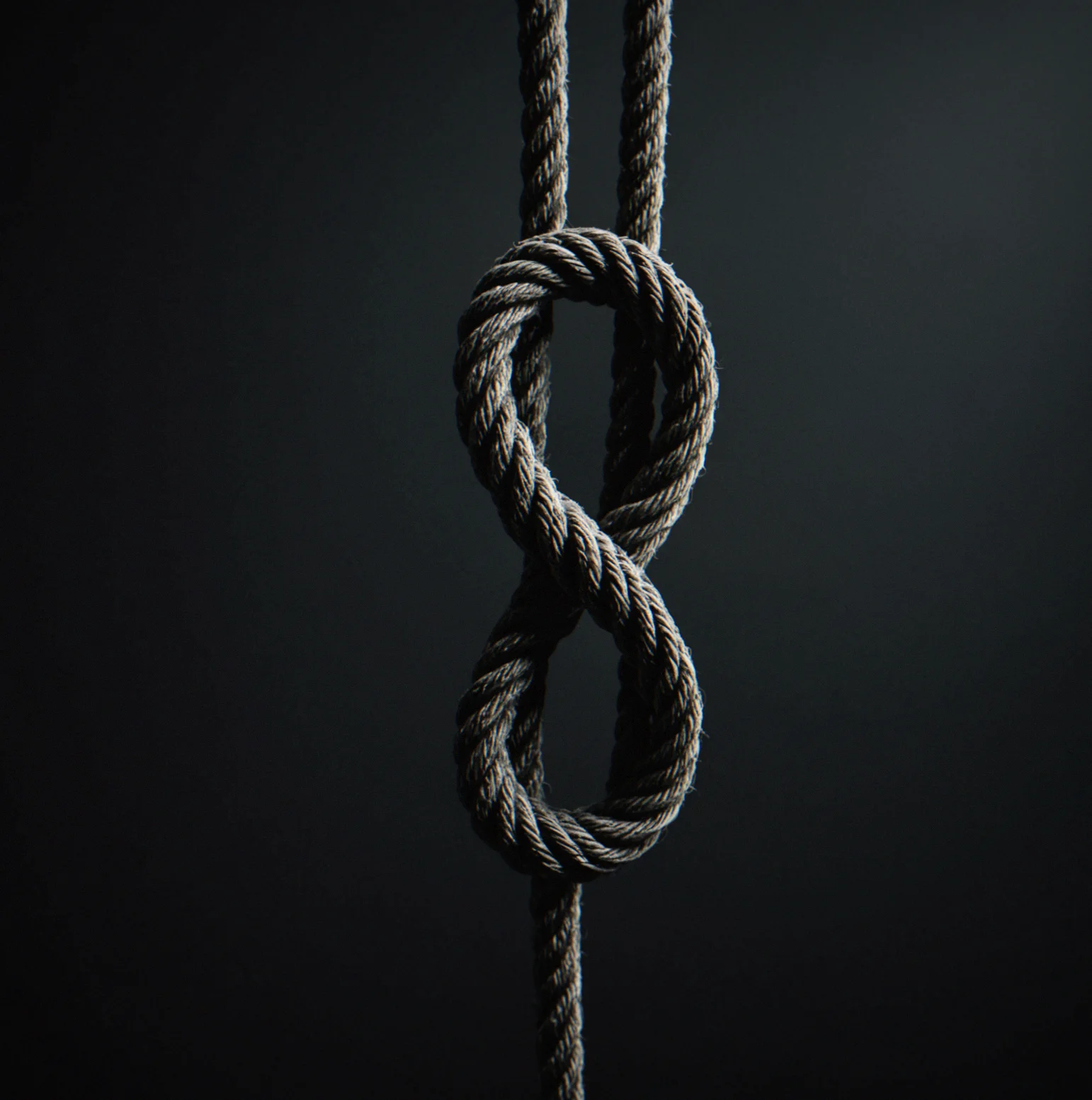 Knotted rope in a dark minimal space, waiting for you to untangle it